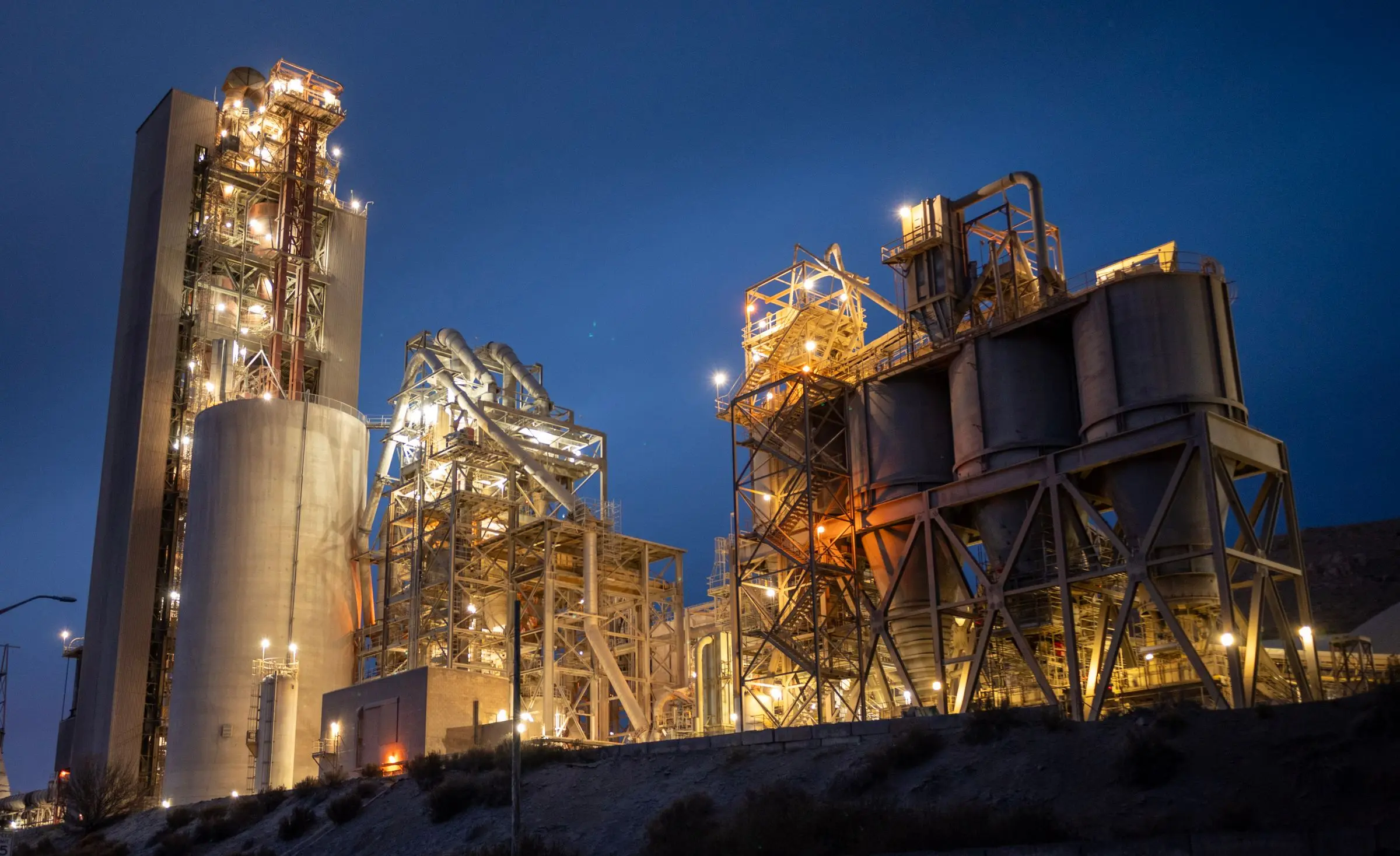 A cement plant lit up at dusk