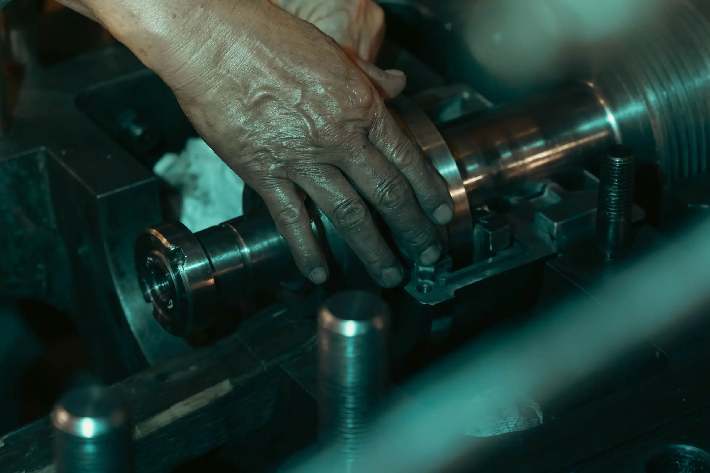 A technician's hands on a machined shaft