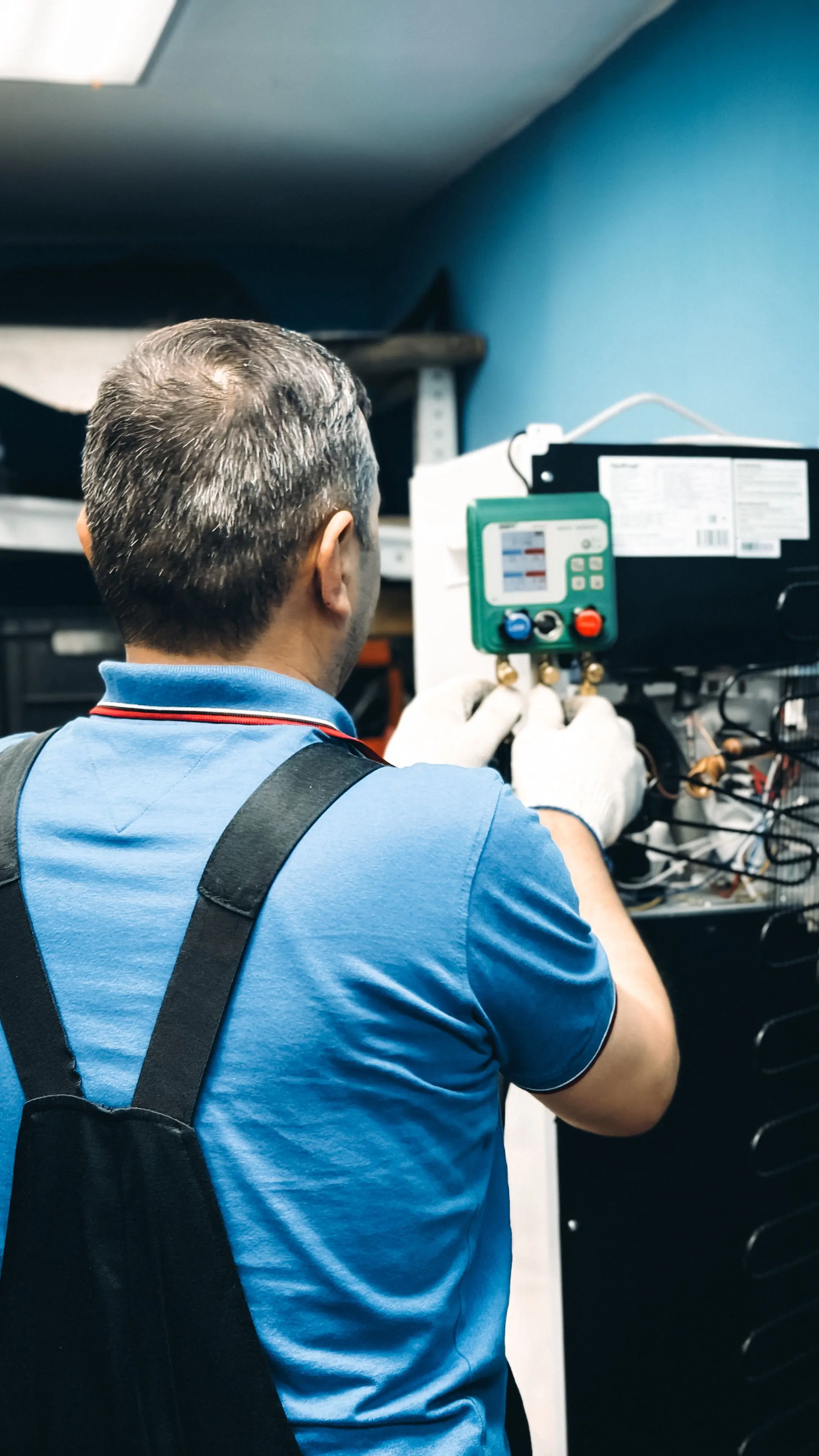 A heating and air technician checking pressure gauges