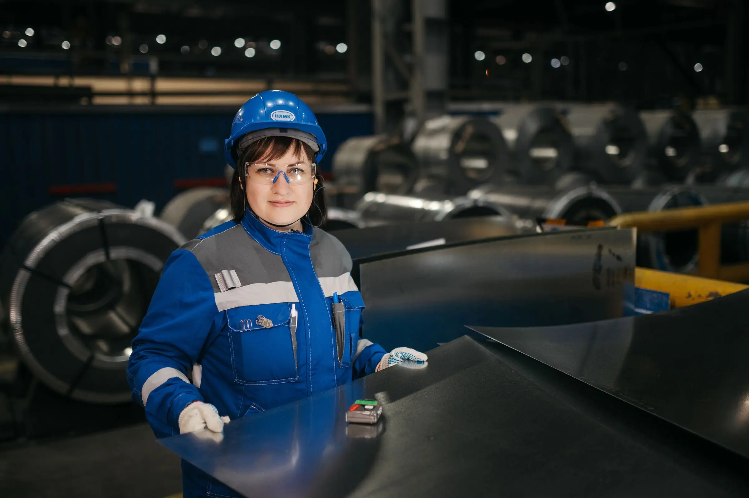 An inspector checking steel coils on the plant floor