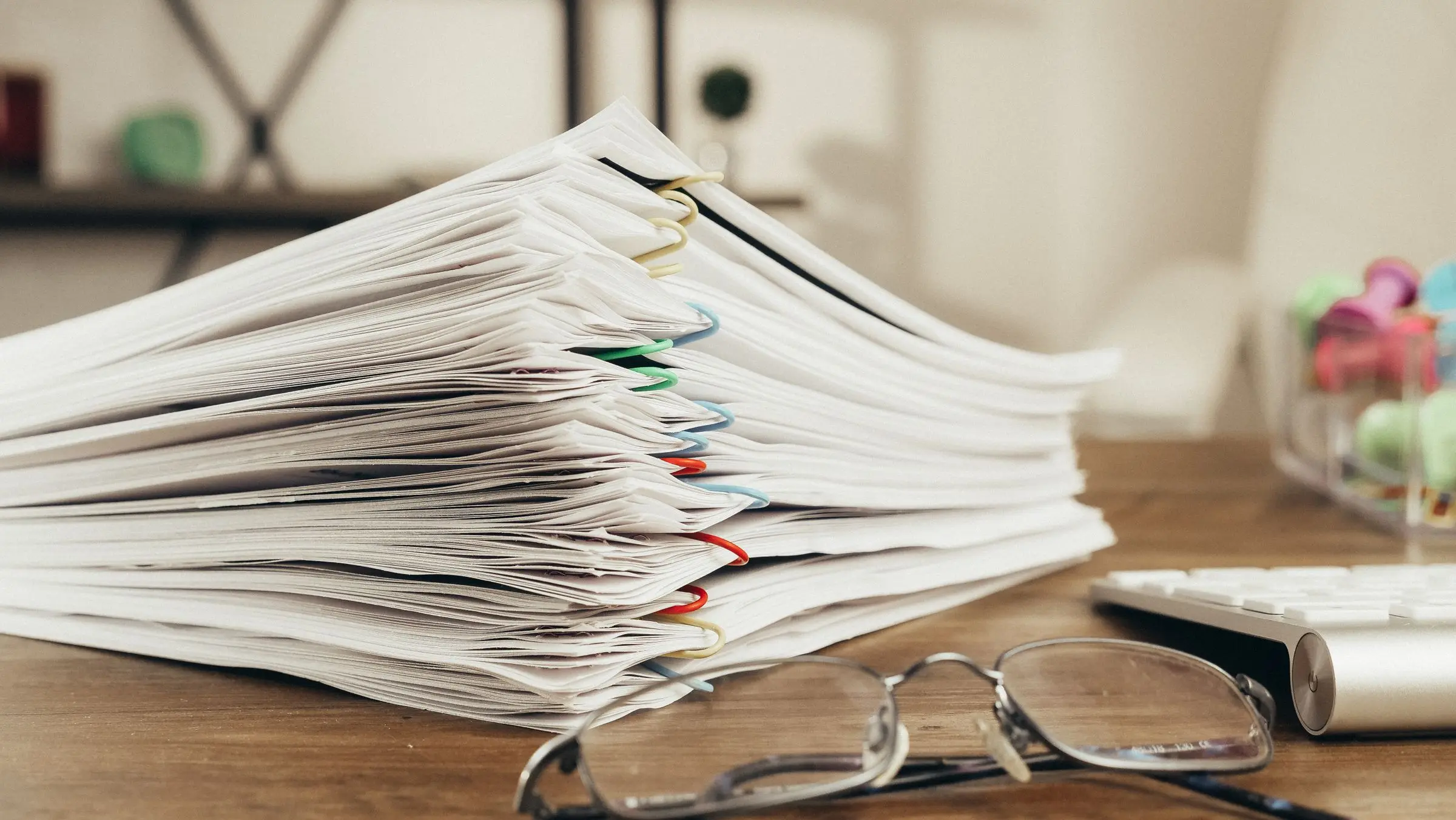 A tall stack of tender documents on a desk